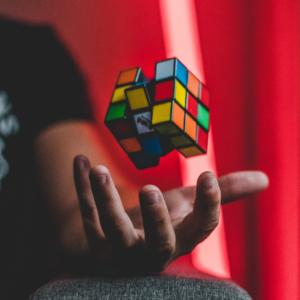 Rubics cube hovering above mans hand